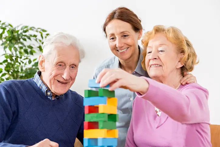 Senior couple using wooden blocks as a form of occupational therapy at Pilgrim Manor Skilled Nursing and Rehabilitation’s facility in Bossier City