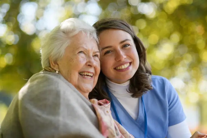 Senior woman smiling with occupational therapist outside of nursing facility in Bossier City, LA