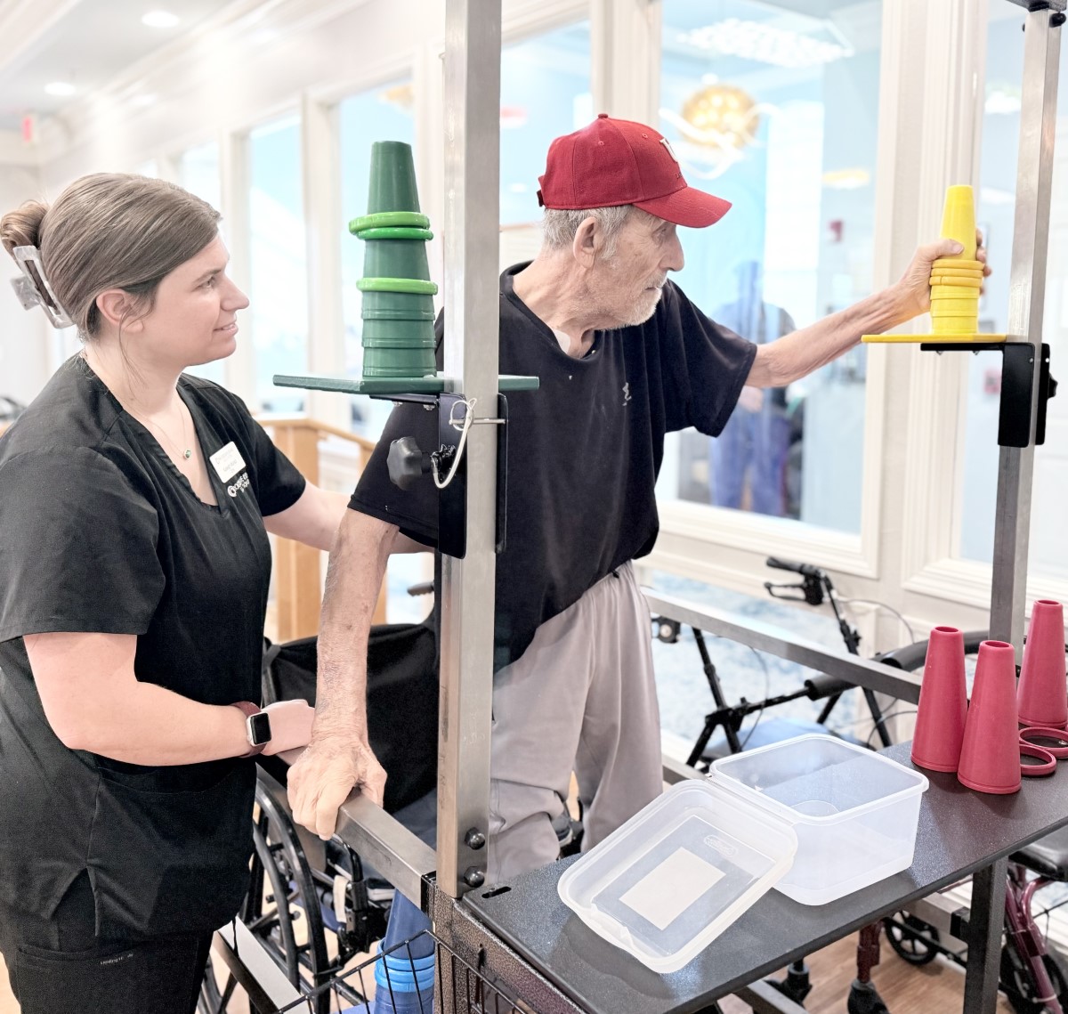 man standing doing physical therapy with female nurse