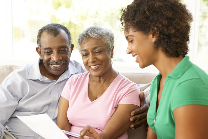 An elderly couple reviewing a financial document with a nursing home worker in Bossier City