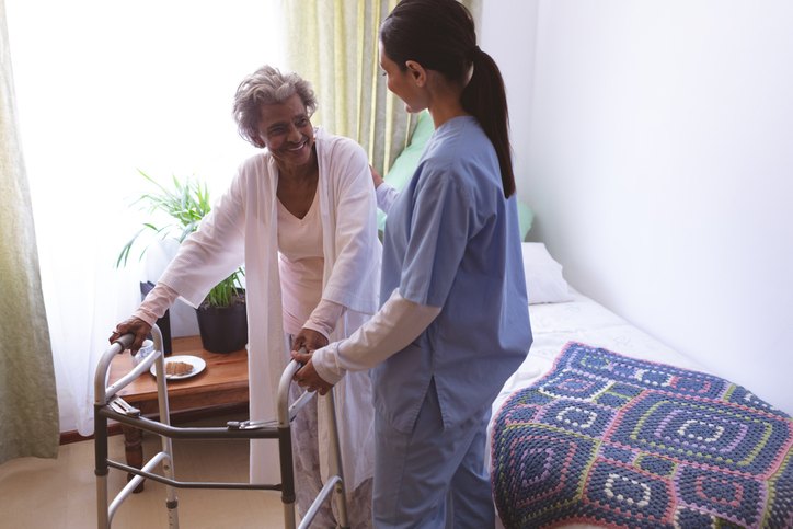 Nurse assists elderly woman with walker in Bossier City, LA, highlighting Post-Surgery Care support