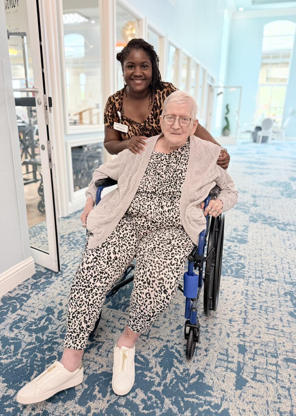 Staff member helping a resident in a wheelchair at Pilgrim Manor
