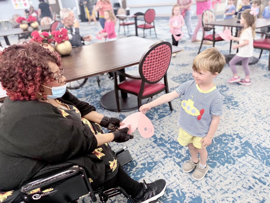 Children bringing gifts to residents during a Pilgrim Manor event