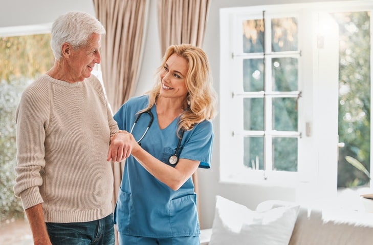 Caregiver assisting a senior man during short-term rehabilitation