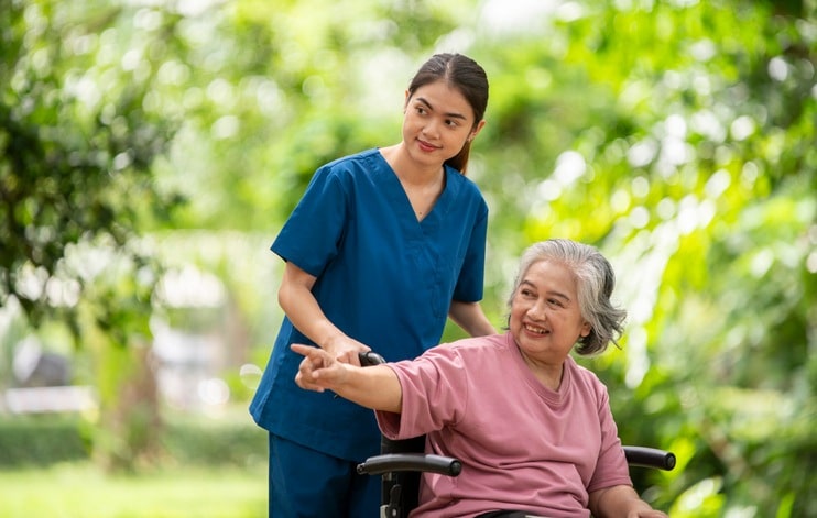 Senior woman with dementia going outside with a nurse